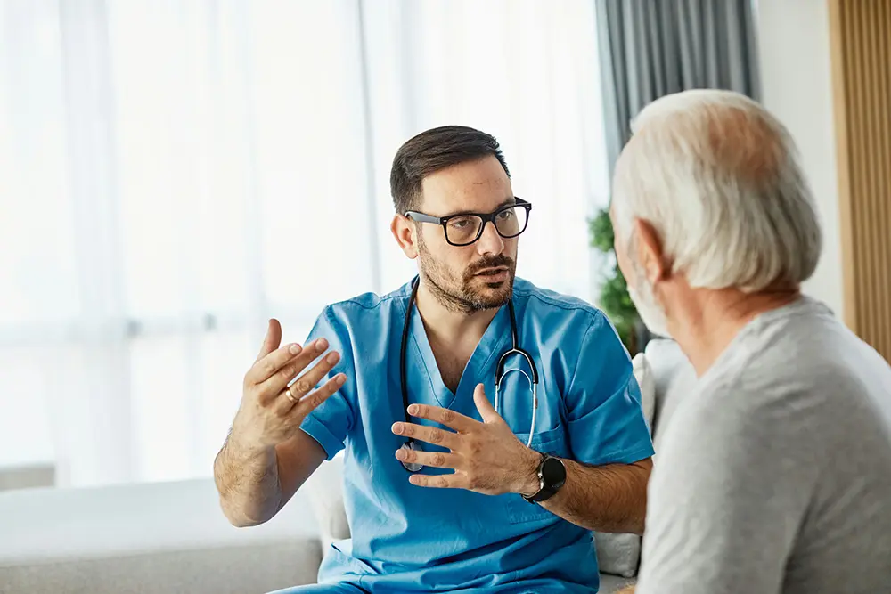 an elderly man listening to his therapist discuss addiction treatment for recovery